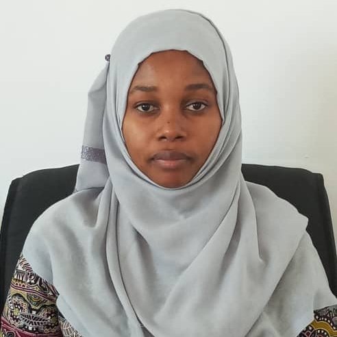 A Tanzanian woman wearing a light grey jihab.