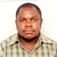 A Tanzanian man wearing a light brown shirt.