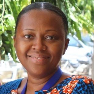 A smiling Tanzanian woman with a colourful shirt.